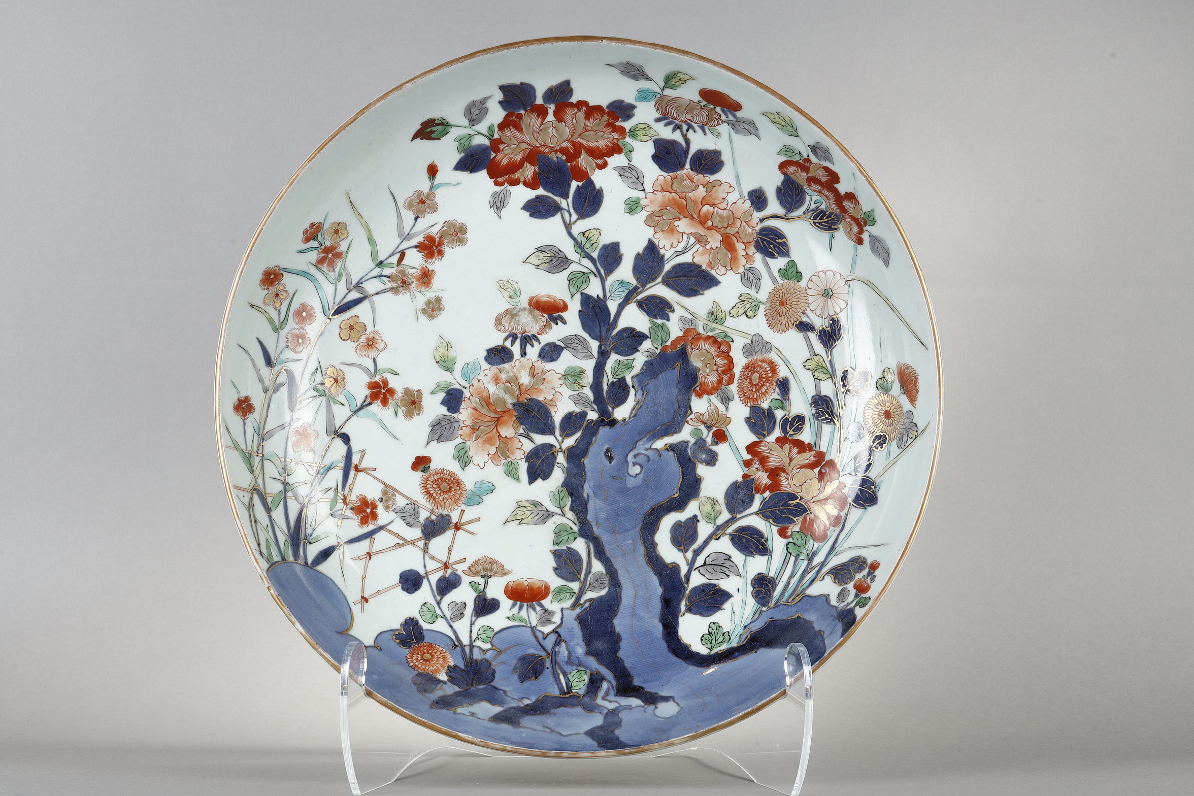 Large dish in porcelain polychrom with rock and numerous flowers  
Arita kilns Japan about 1700 
Diam 47cm